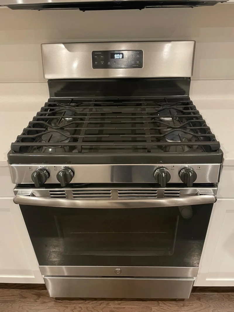 Clean stainless steel gas range in a white kitchen